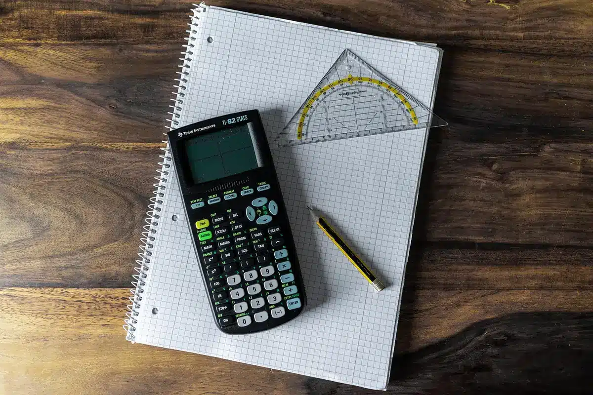 Personne notant ses compétences et outils sur un carnet près d'une fenêtre