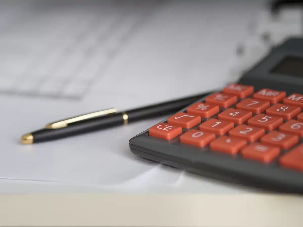Calculatrice et factures sur un bureau symbolisant cotisations et charges d'un indépendant