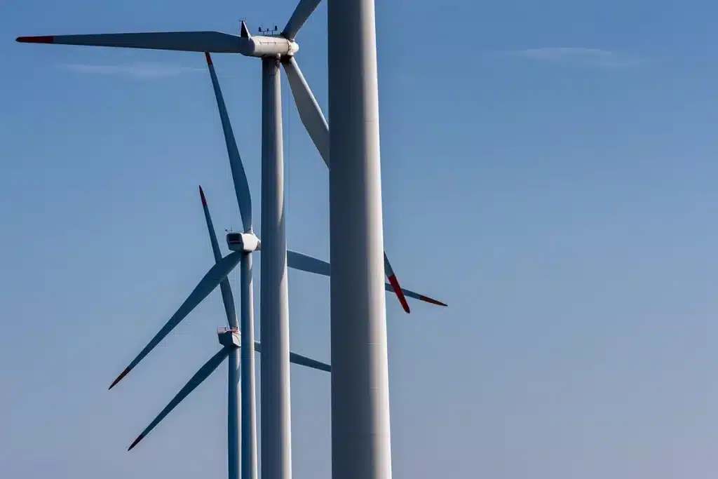 Chantier d'infrastructure éoliennes et lignes électriques sous ciel dramatique, image anonyme