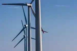 Chantier d'infrastructure éoliennes et lignes électriques sous ciel dramatique, image anonyme