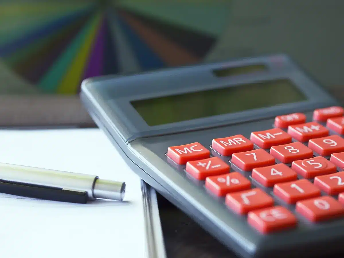 Fiche de paie et calculatrice sur un bureau en lumière du jour