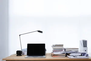 Bureau en journée avec documents et calculatrice près d'une fenêtre