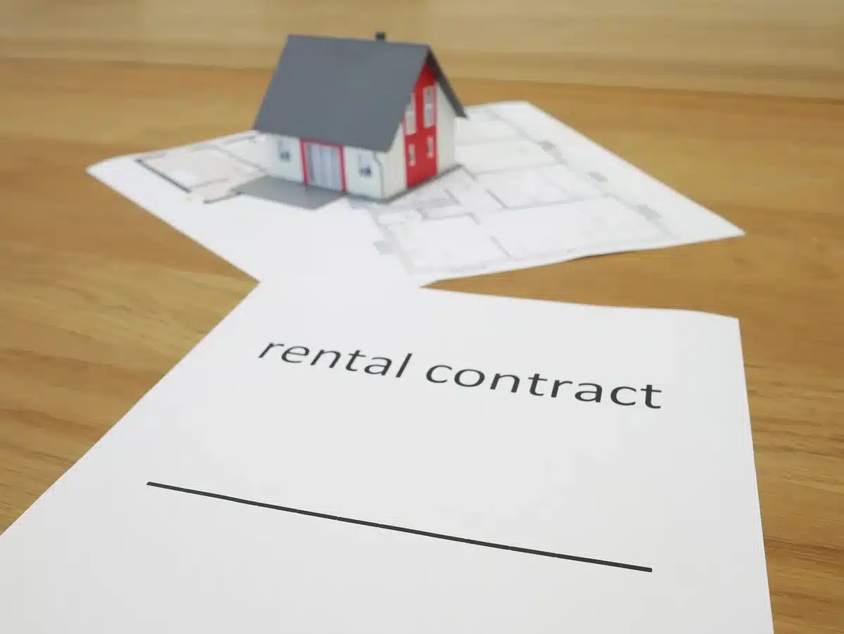 Contrat de location et clés posés sur une table, documents fiscaux en plein jour