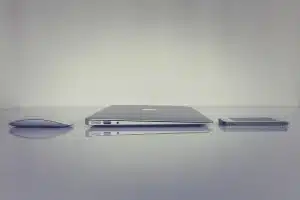 Bureau en journée avec ordinateur, smartphone et documents financiers flous