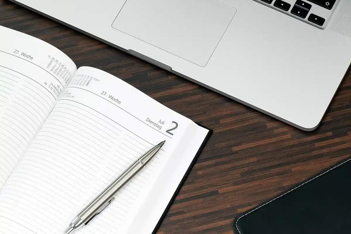 Chef de projet annotant un planning sur un bureau éclairé par la journée