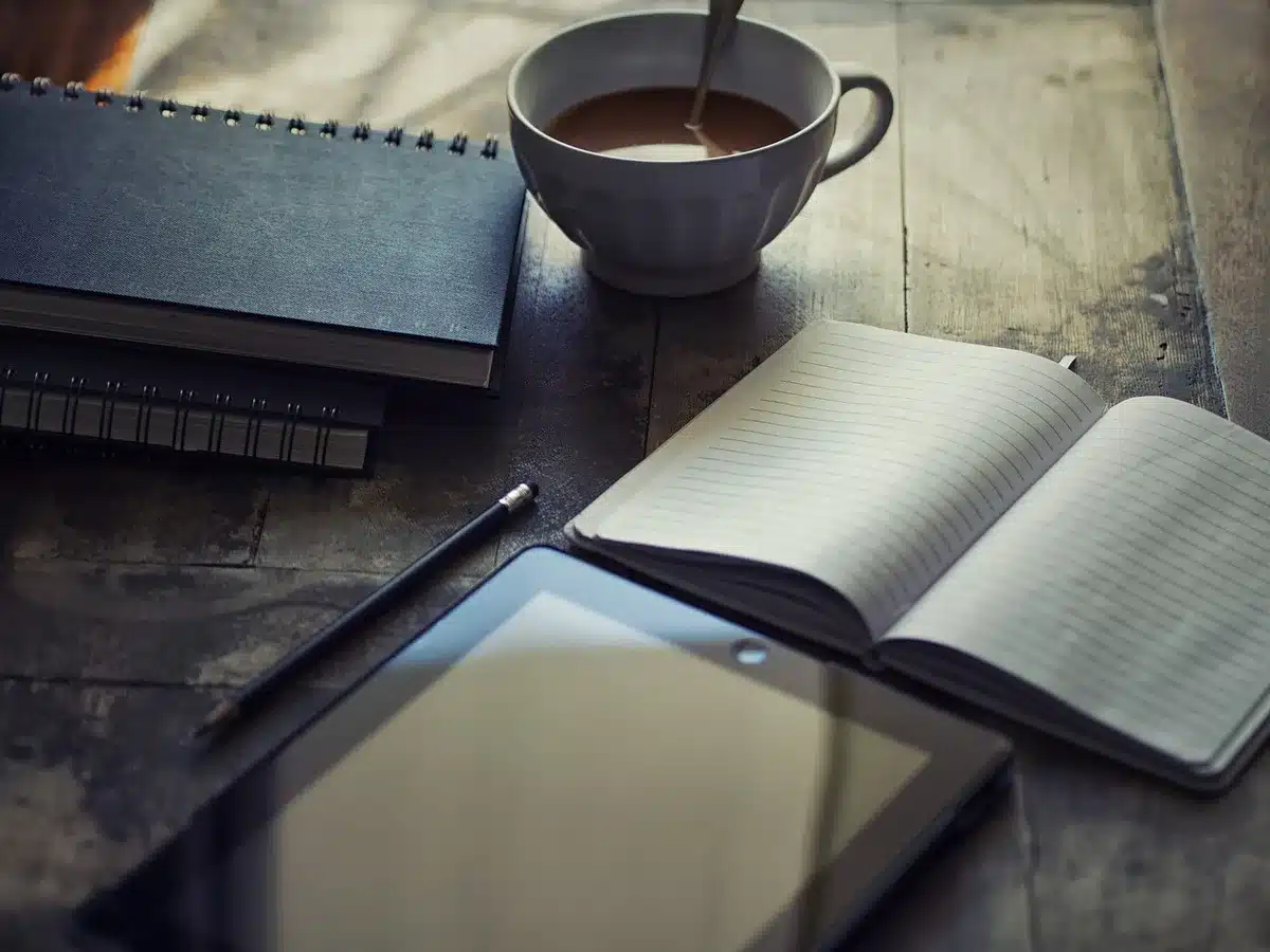 Ordinateur portable avec fenêtre et notes montrant intégration de l'IA dans l'écriture