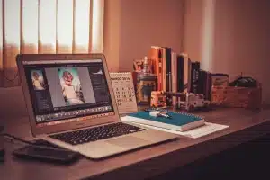 Bureau lumineux avec ordinateur portable affichant du code et carnet de notes