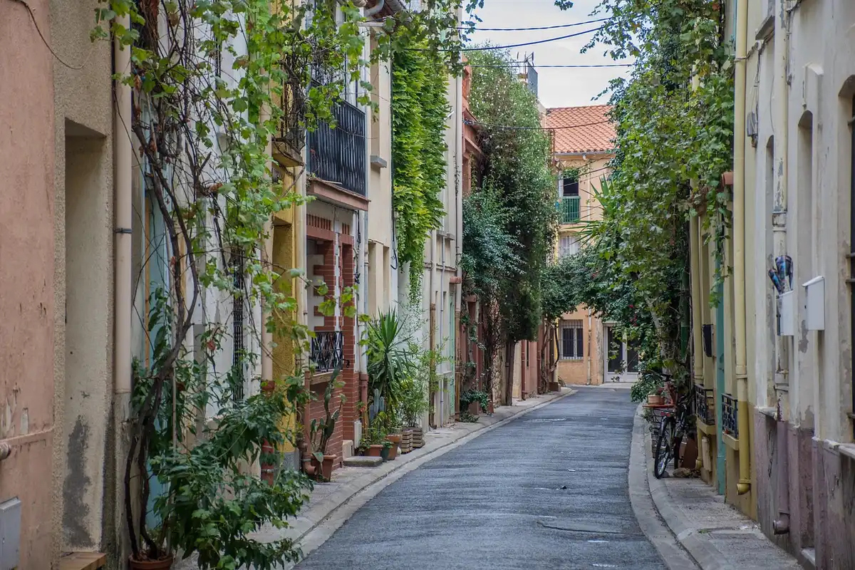 Fenêtre d'appartement ouverte sur une rue commerçante en journée