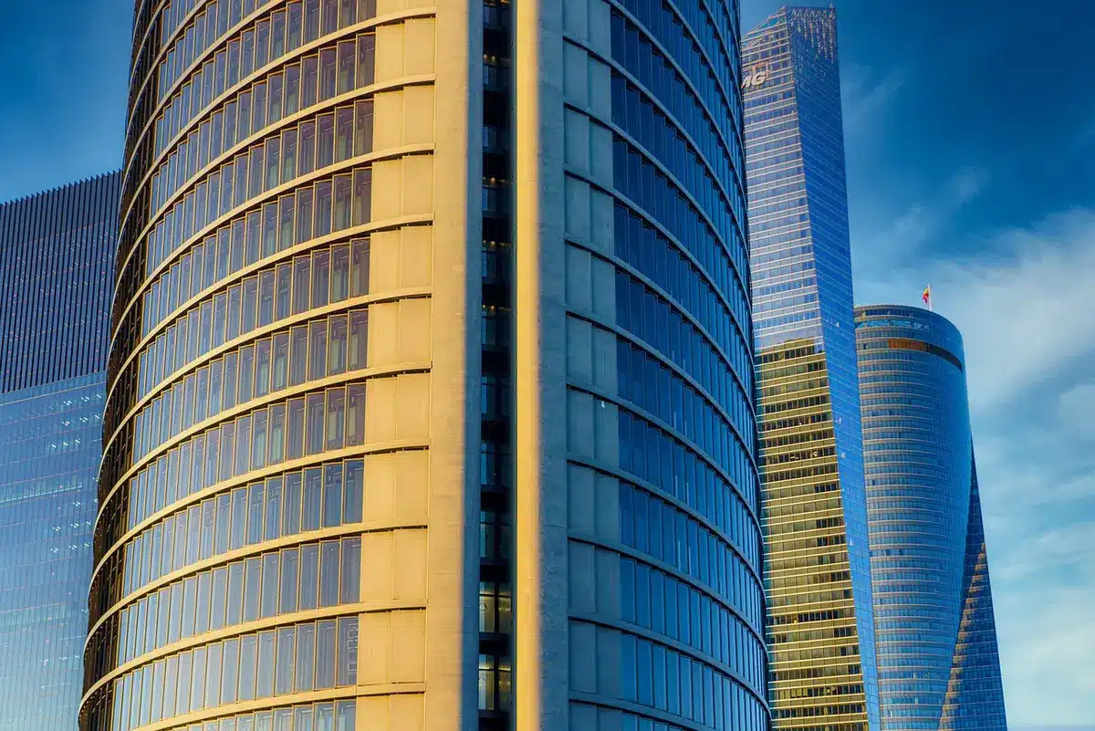 Personne anonymisée organisant relevés et virements sur un bureau ensoleillé