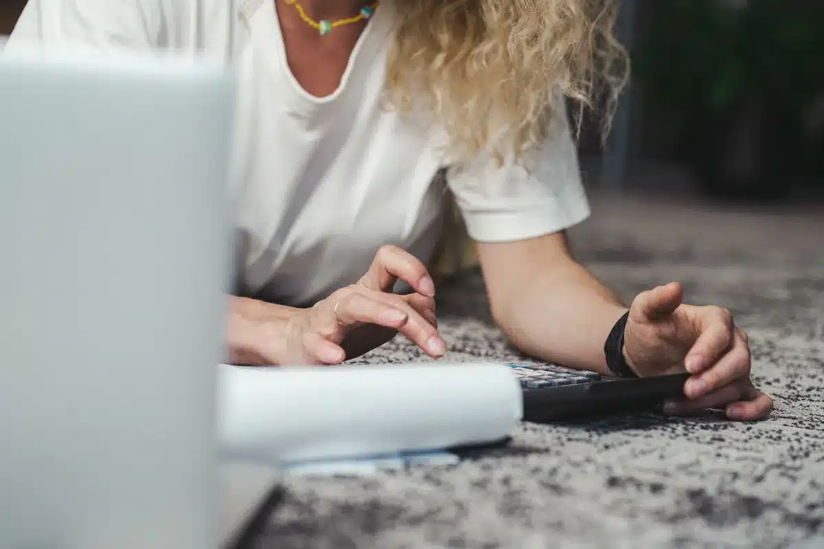 Bureau à domicile en journée avec papiers, calculatrice et mains triant des documents