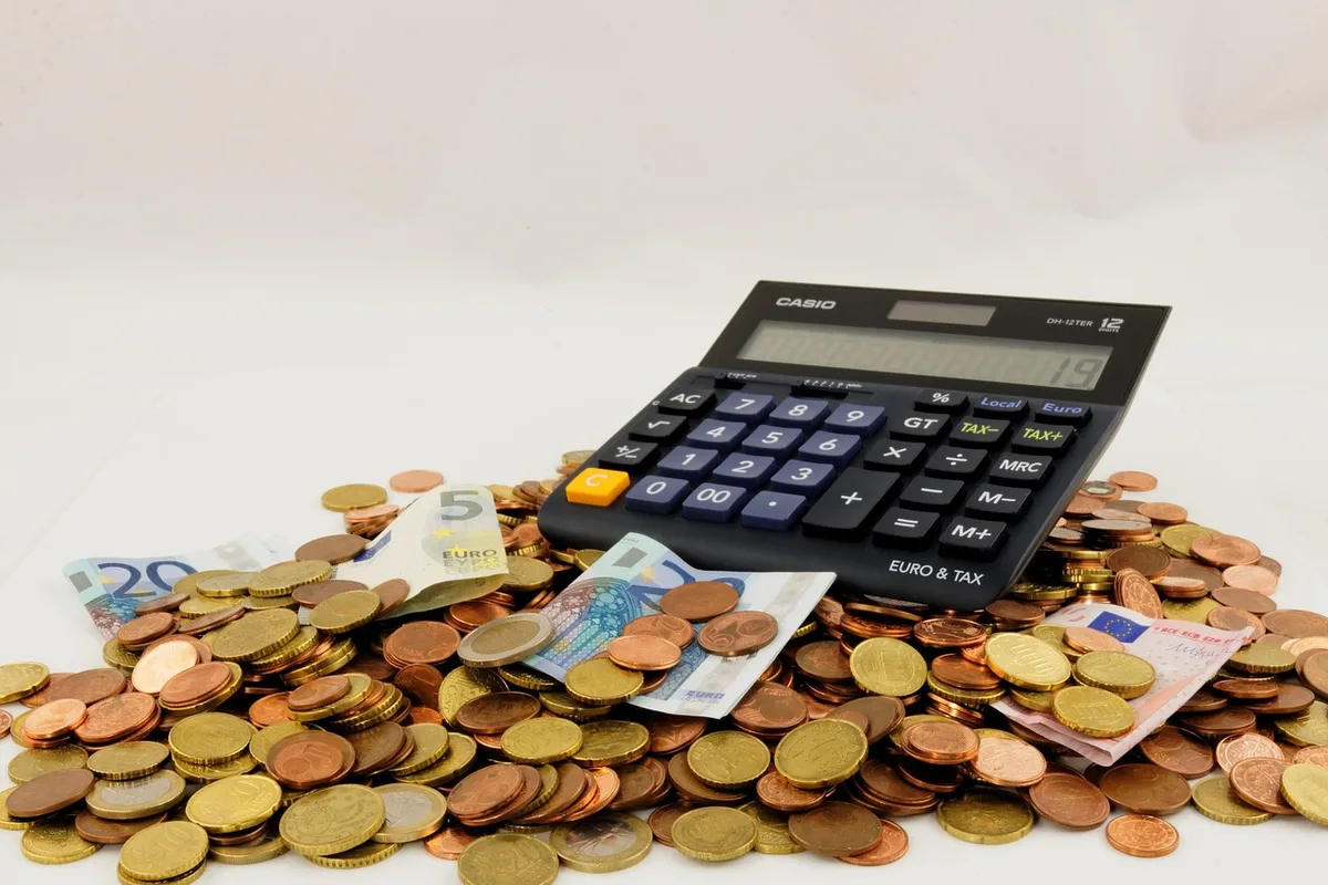 Documents fiscaux et calculatrice sur un bureau en lumière du jour
