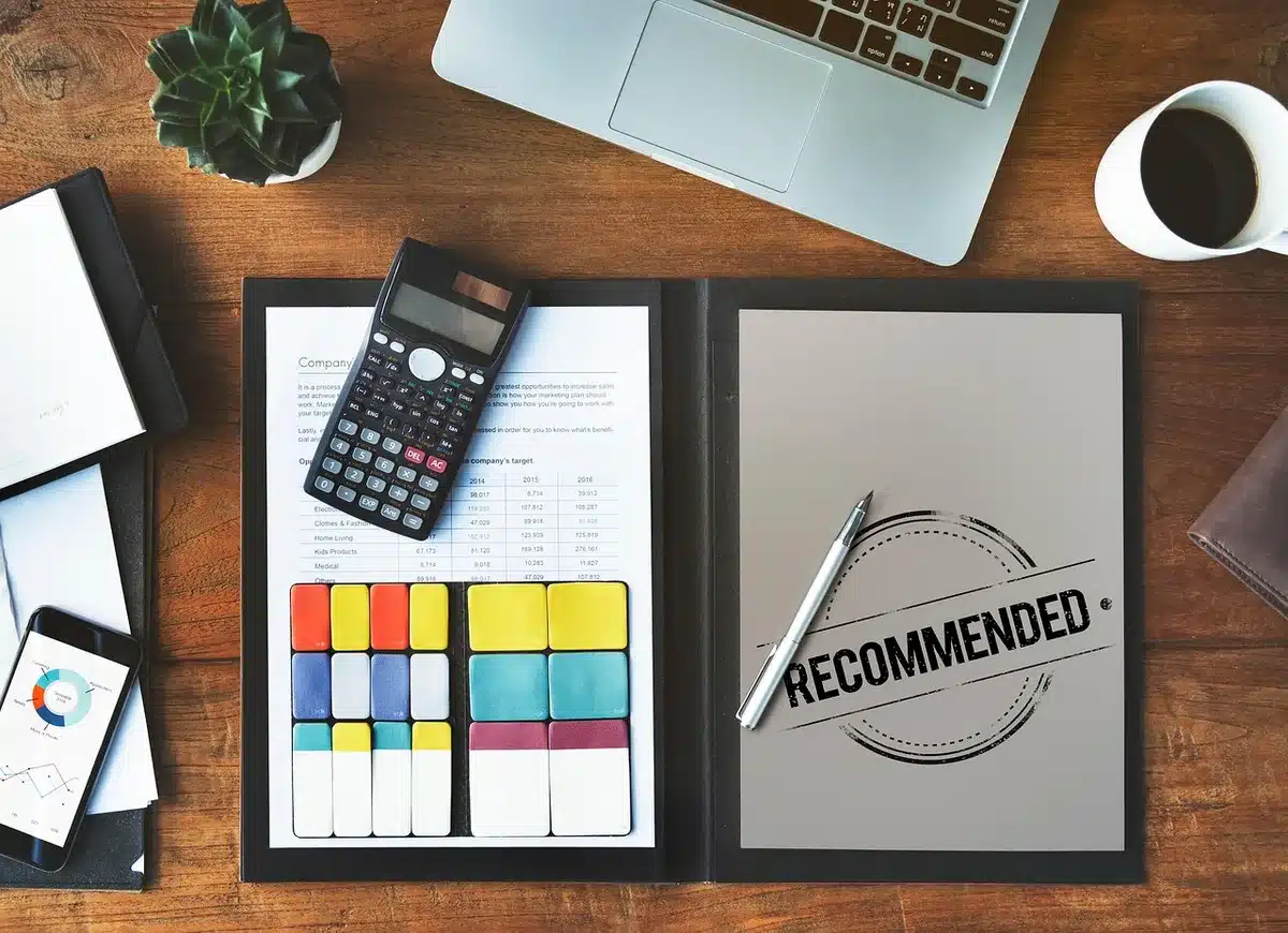 Calculatrice et documents d'épargne sur une table indiquant taux brut et net