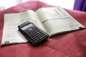 Table de cuisine en journée avec documents bancaires et calculatrice, lumière du jour