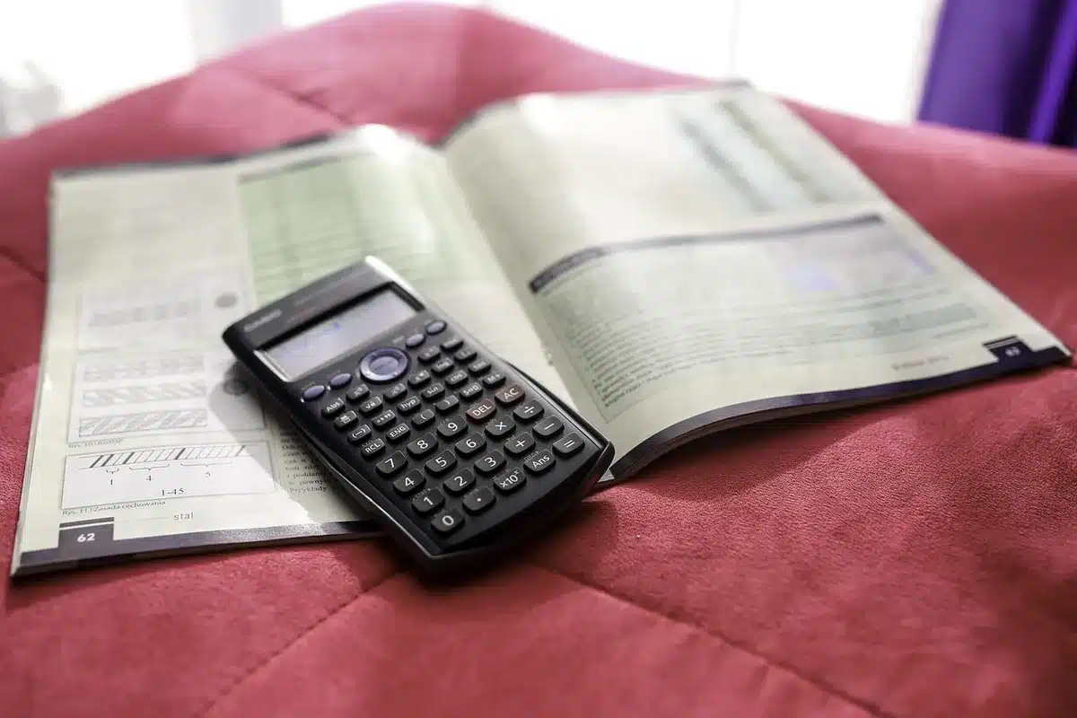Table de cuisine en journée avec documents bancaires et calculatrice, lumière du jour