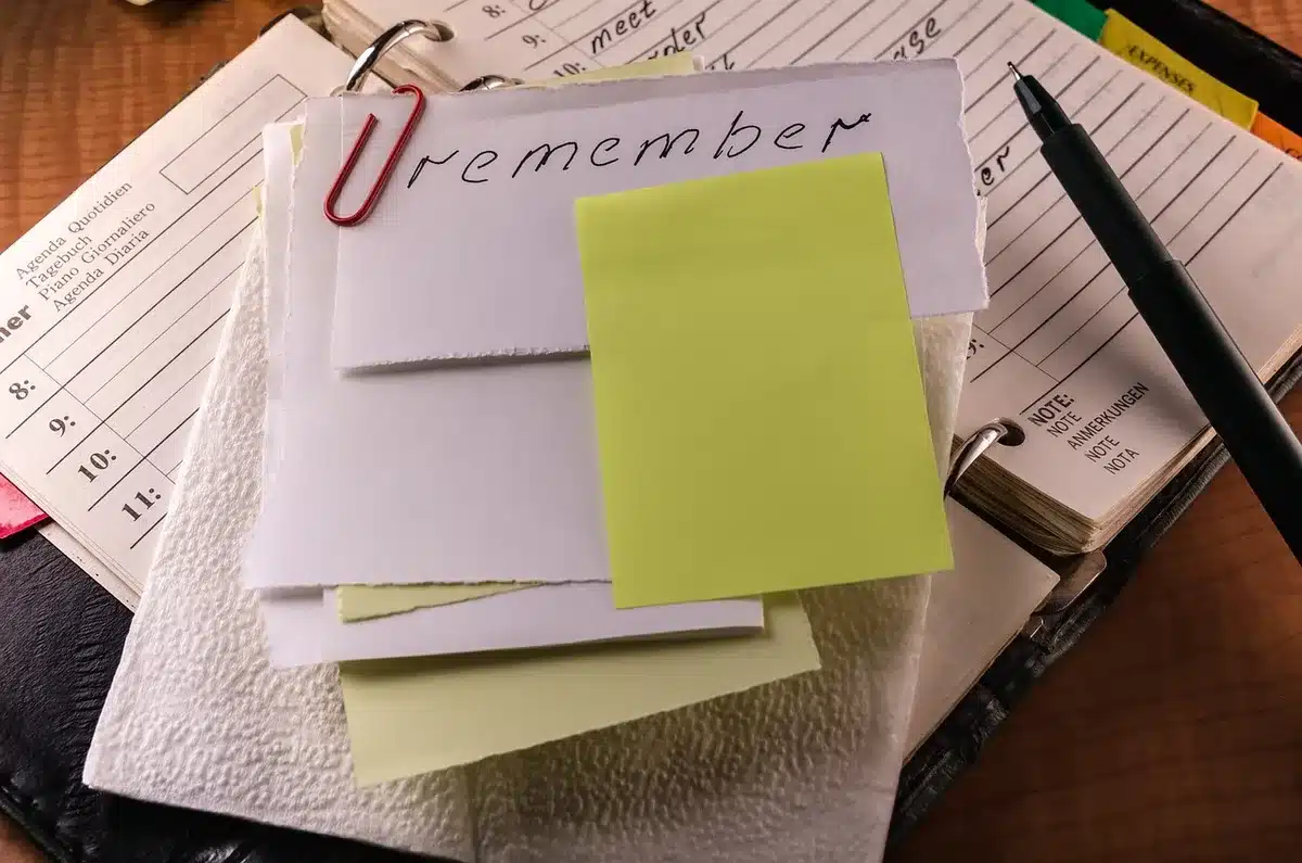 Investisseur annotant un document d'information clés sur un bureau ensoleillé