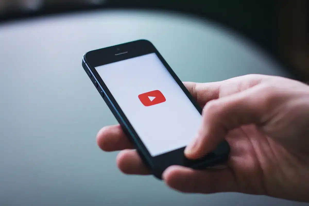 Personne utilisant un smartphone près d'ordinateur montrant l'exposition sur les réseaux