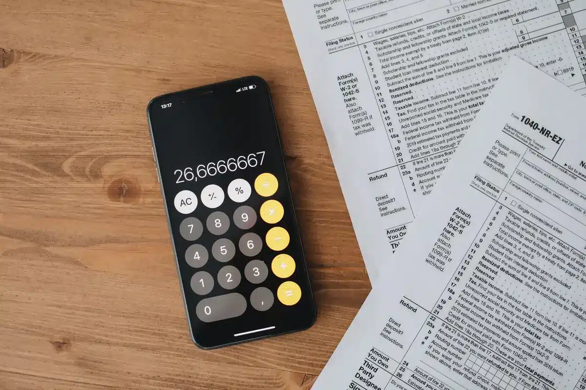 Documents fiscaux, calculatrice et carnet sur un bureau lumineux