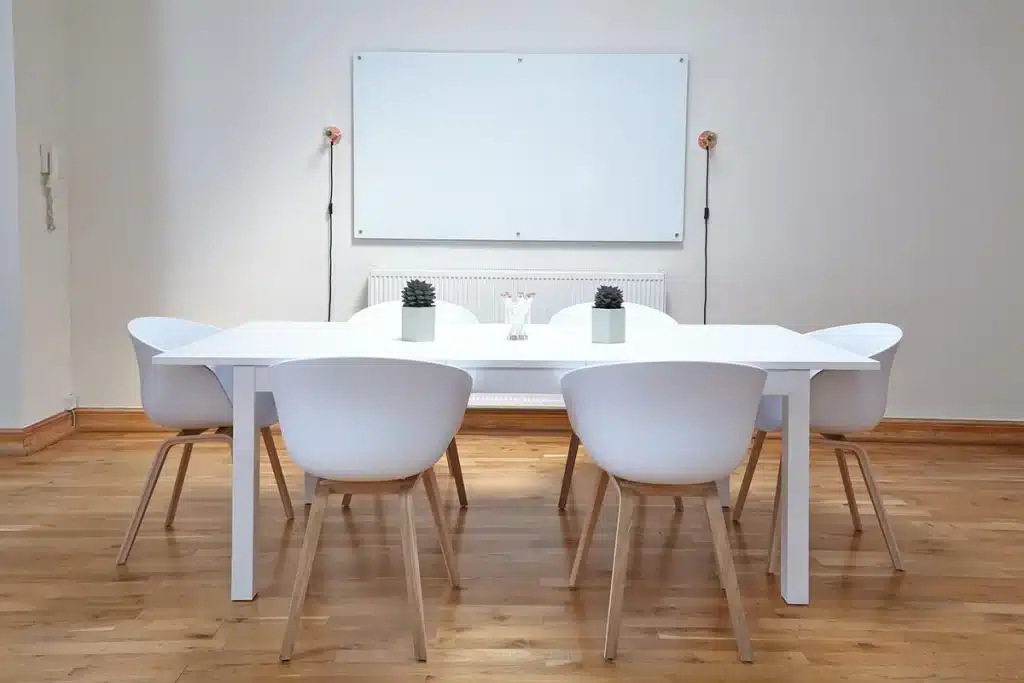 Table de cuisine en journée avec devis de travaux, mains et téléphone posés