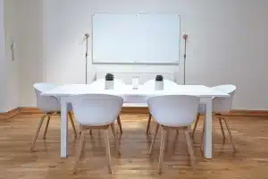 Table de cuisine en journée avec devis de travaux, mains et téléphone posés