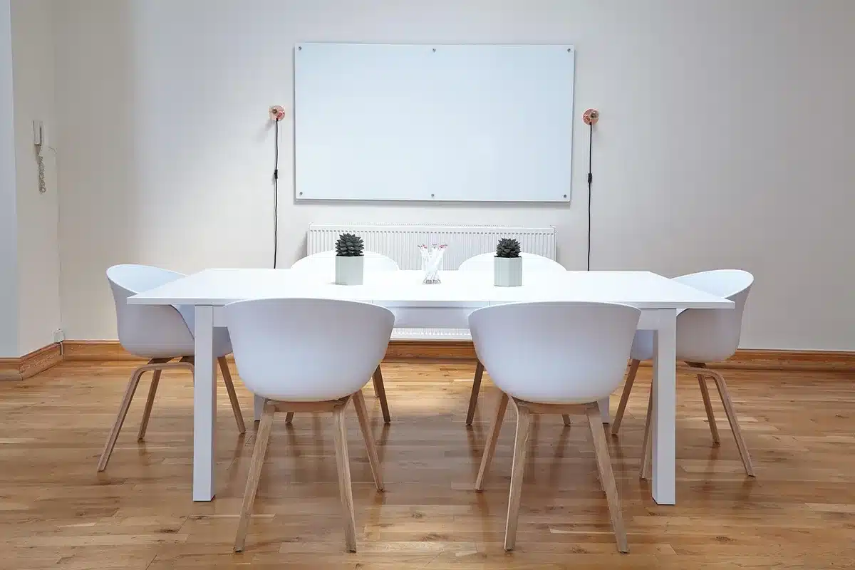 Table de cuisine en journée avec devis de travaux, mains et téléphone posés
