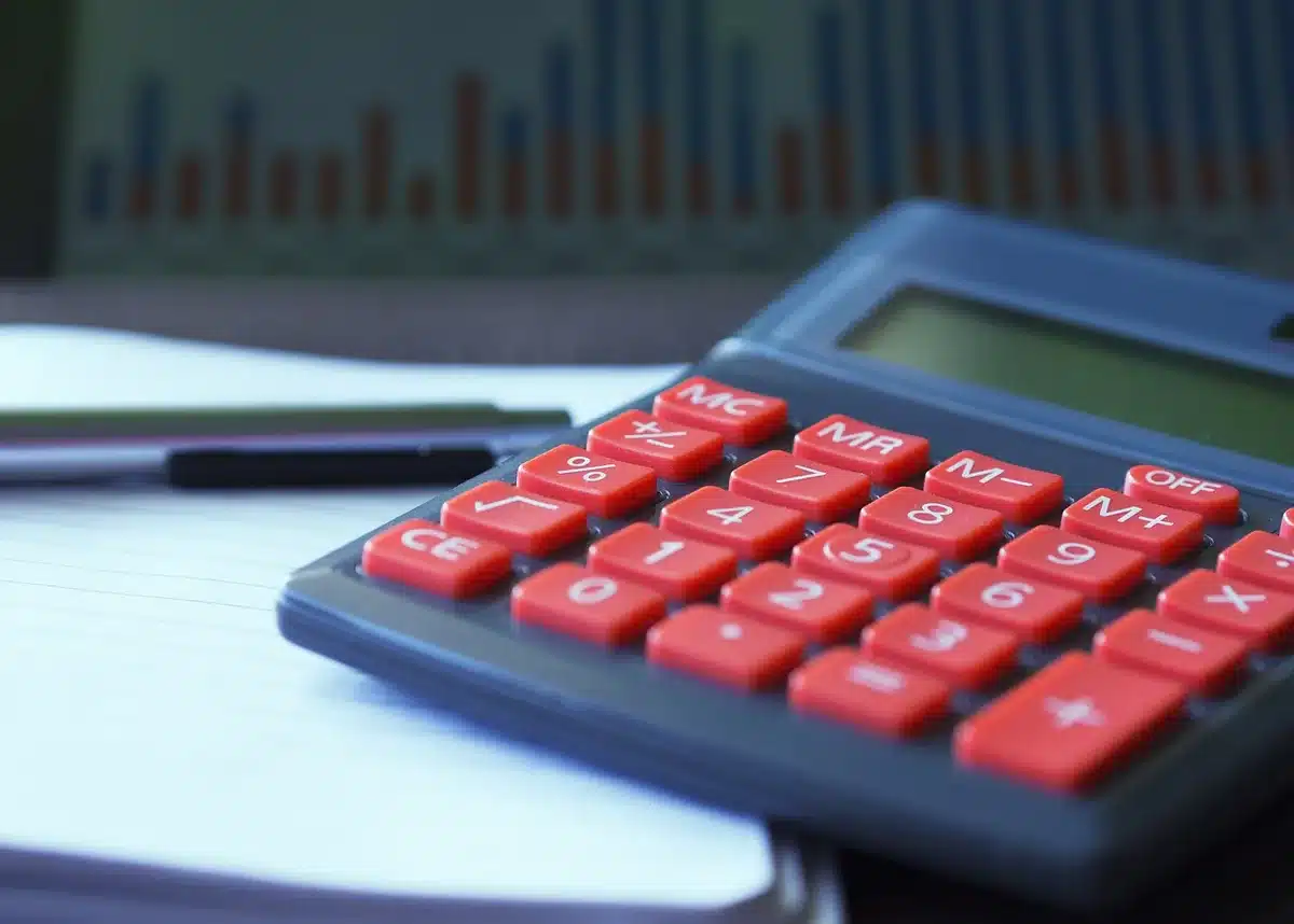 Formulaires fiscaux et calculatrice sur un bureau éclairé par la journée