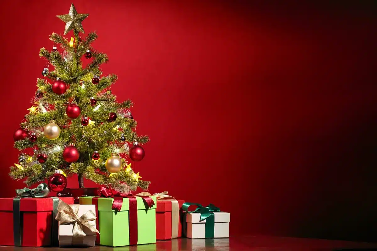 Intérieur lumineux avec famille anonyme échangeant des cadeaux et décorations modestes
