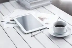 Bureau en journée avec tablette affichant graphiques de portefeuille et feuille de calcul