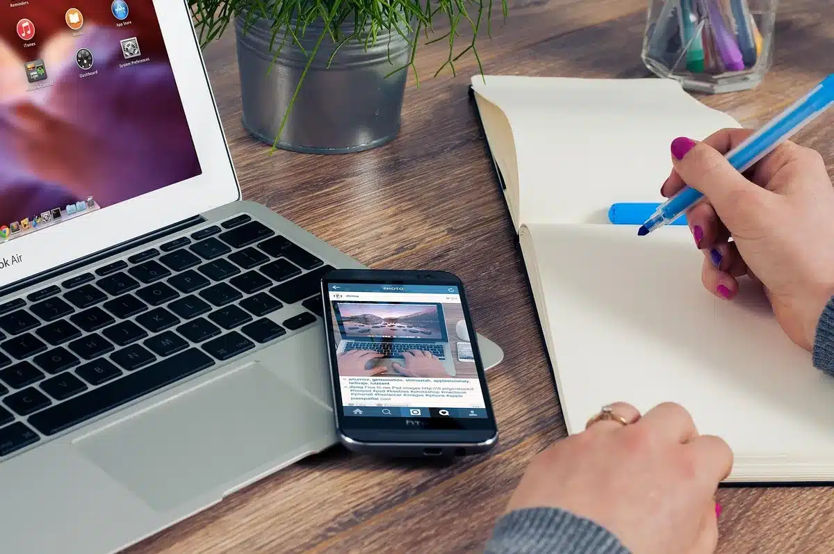 Bureau de coworking lumineux avec carnet ouvert et mains prenant des notes
