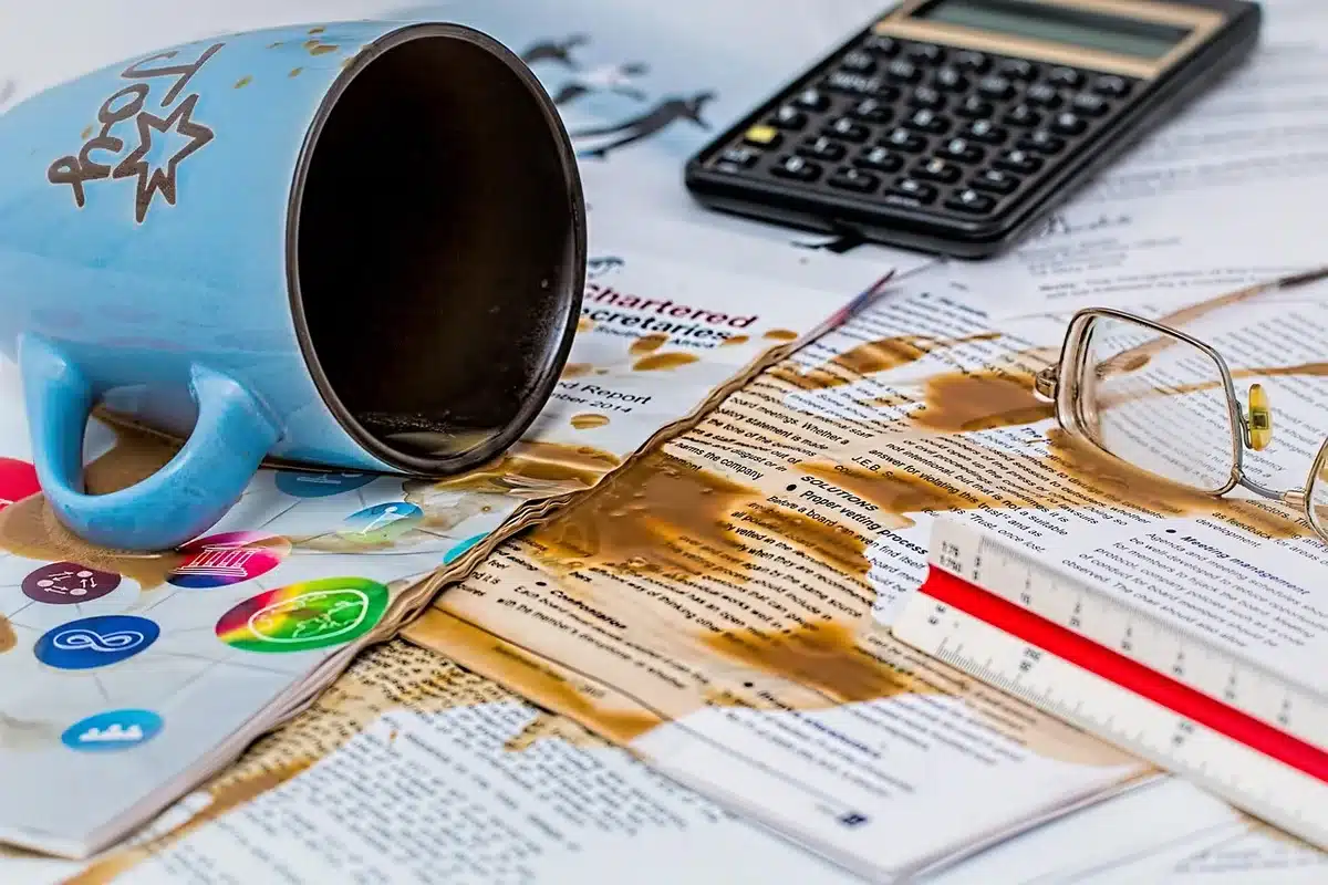 Bureau lumineux avec fiche de paie, calculatrice et tasse près d'une fenêtre