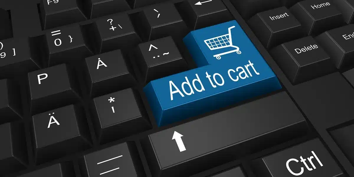 Personne comparant des prix sur un smartphone et un ordinateur